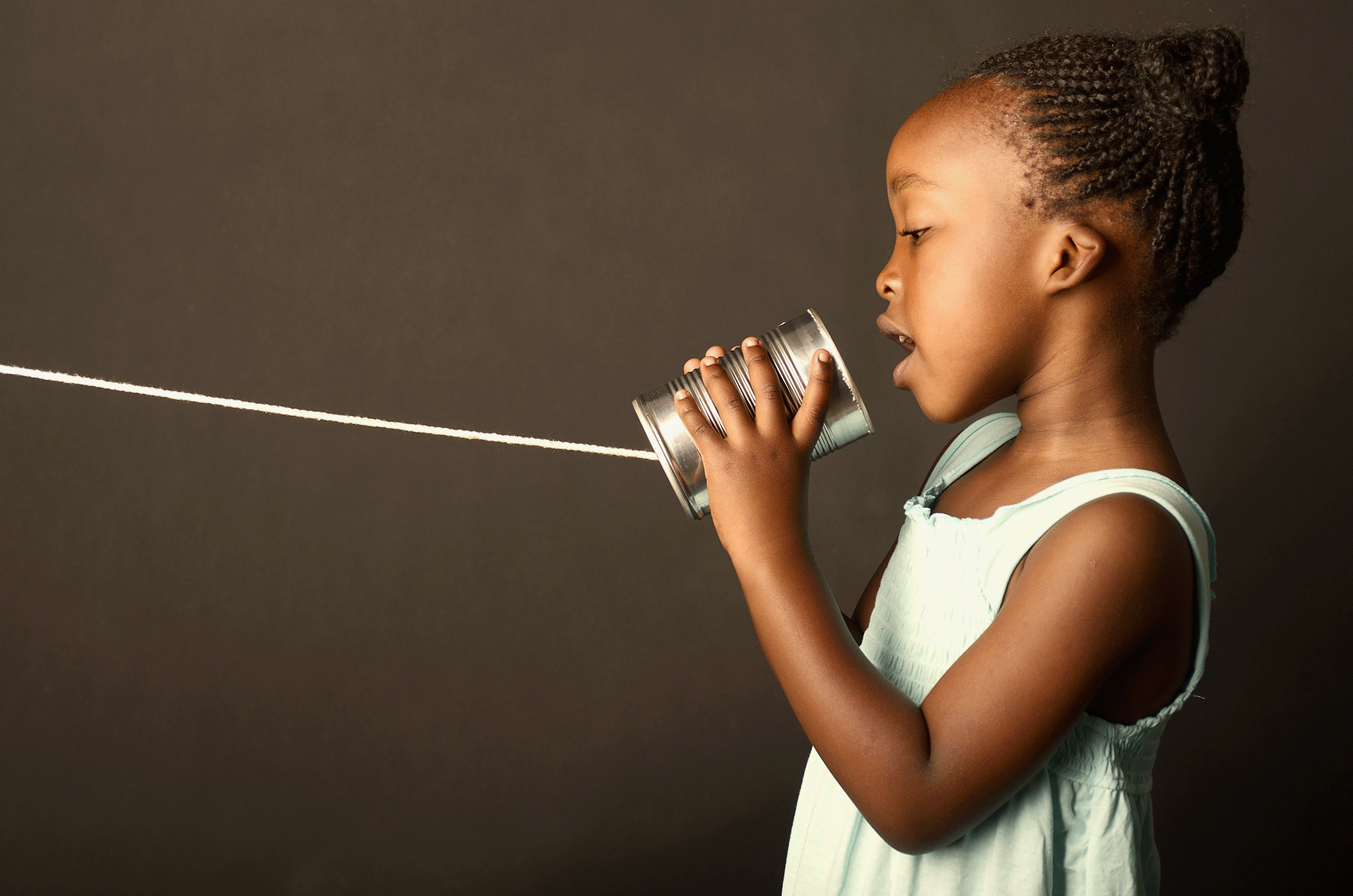 Communication styles: a girl speaks into a can with a string like an old-fashioned game of 