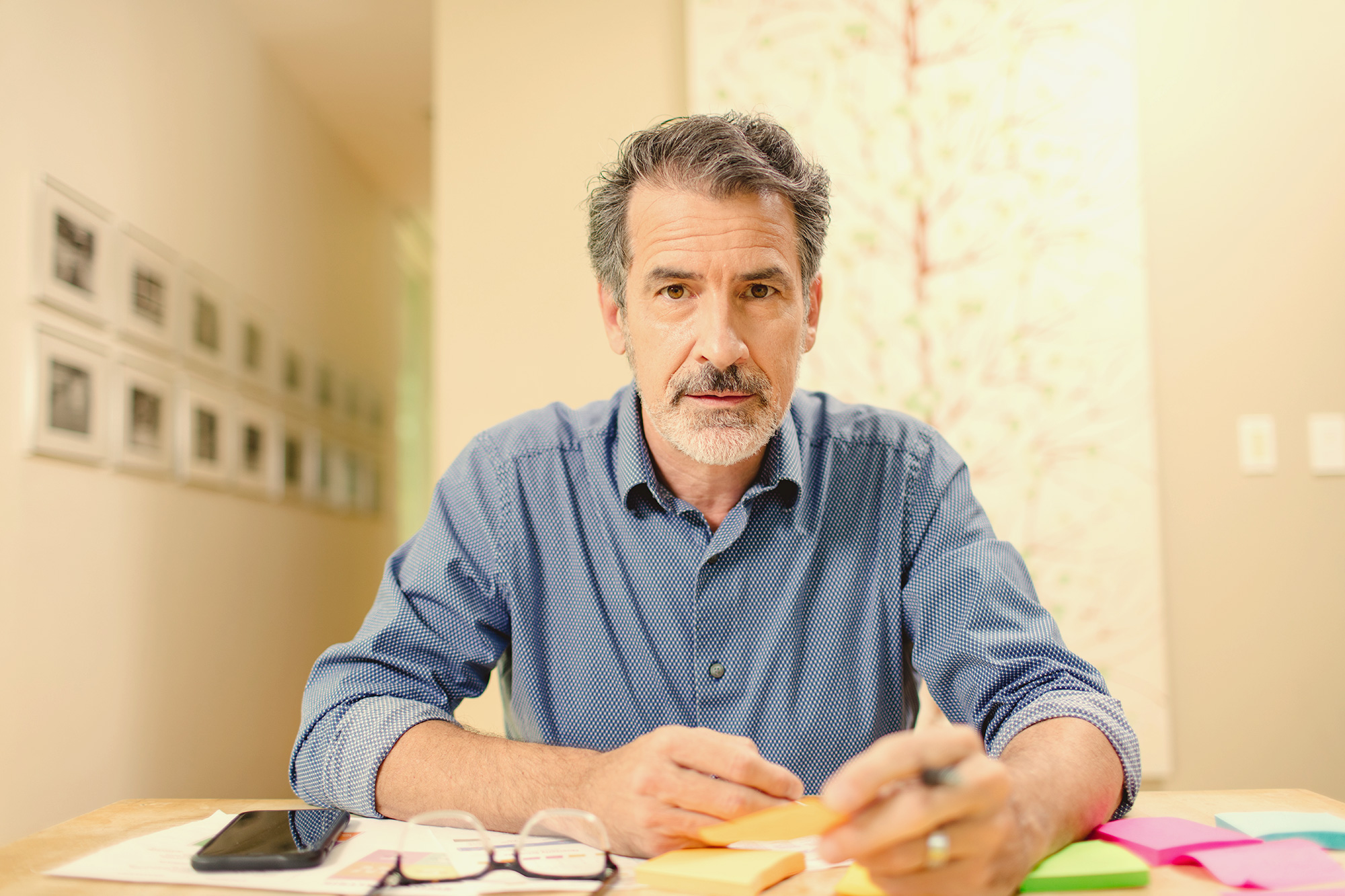 face of man at desk looking into video camera