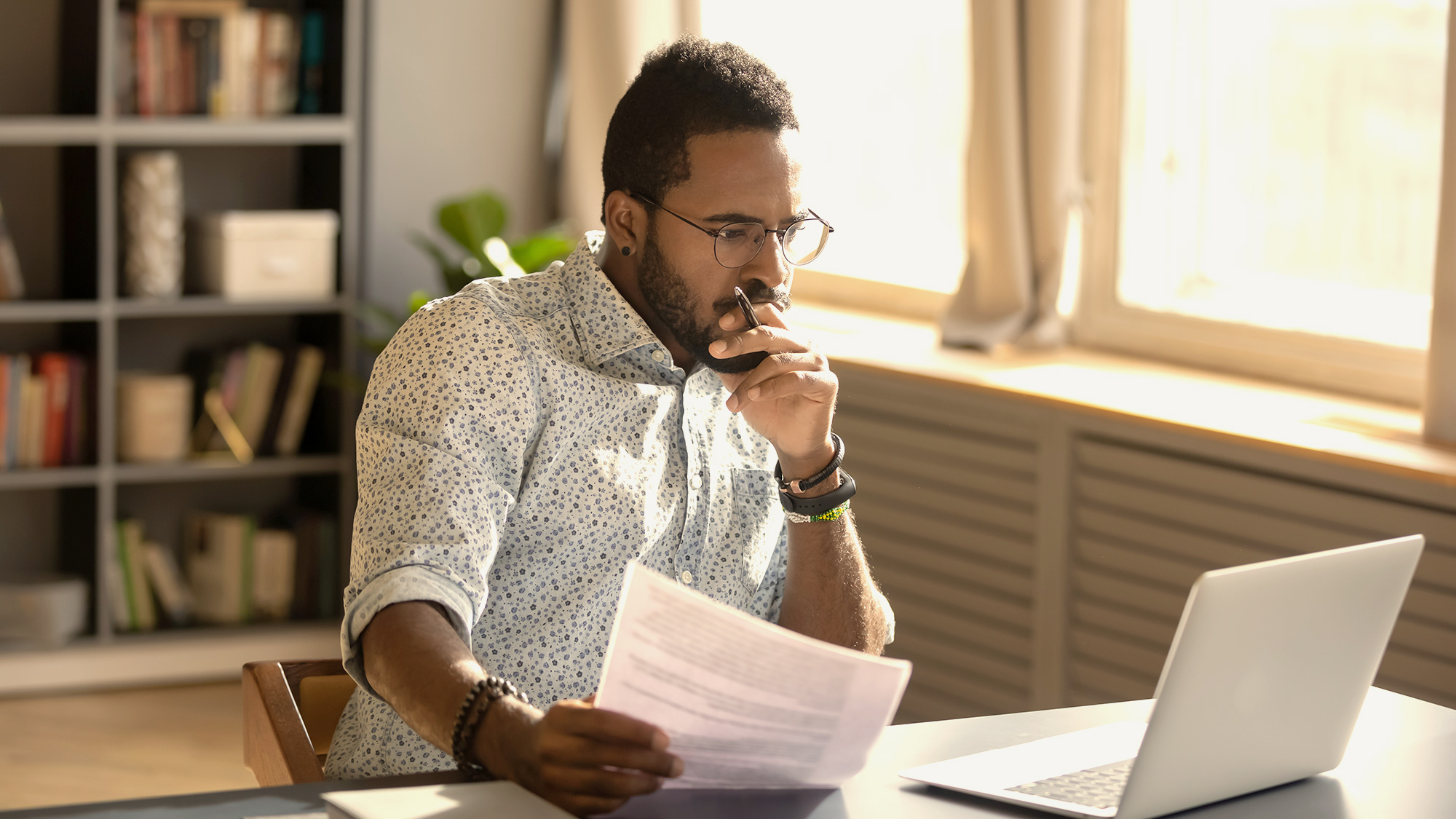 sales manager sitting at computer thinking about challenge